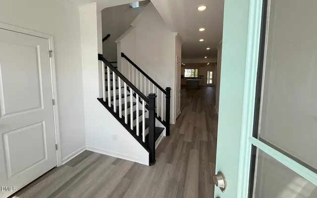 a view of a hallway with wooden floor and stairs