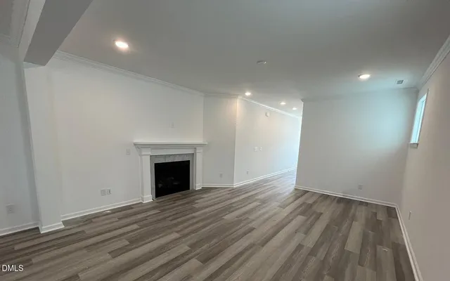an empty room with wooden floor and fireplace