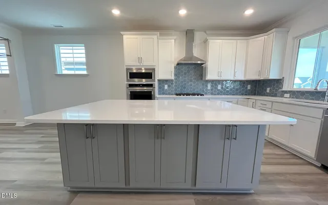 a kitchen with kitchen island white cabinets and sink