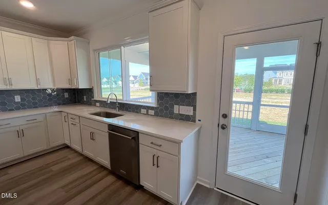 a kitchen with cabinets appliances a sink and a window
