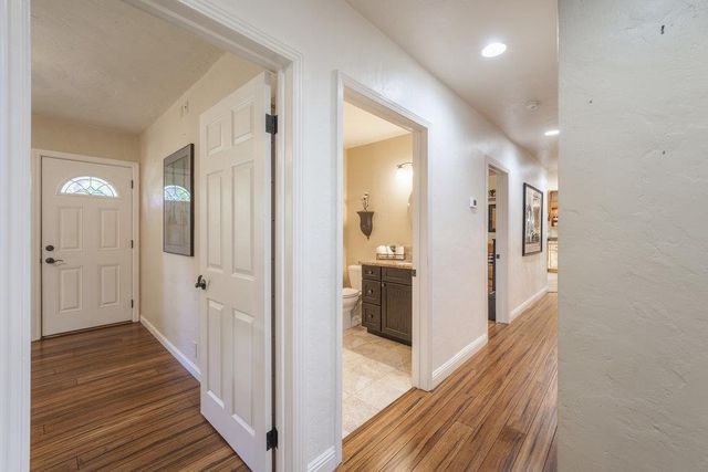 a view of hallway with chandelier and a wooden floor