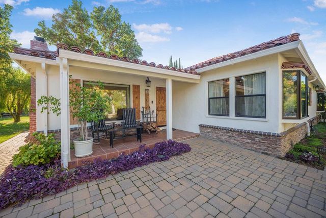 a view of a house with backyard sitting area and garden