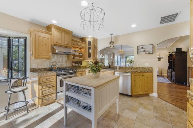 a open kitchen with cabinets and stainless steel appliances
