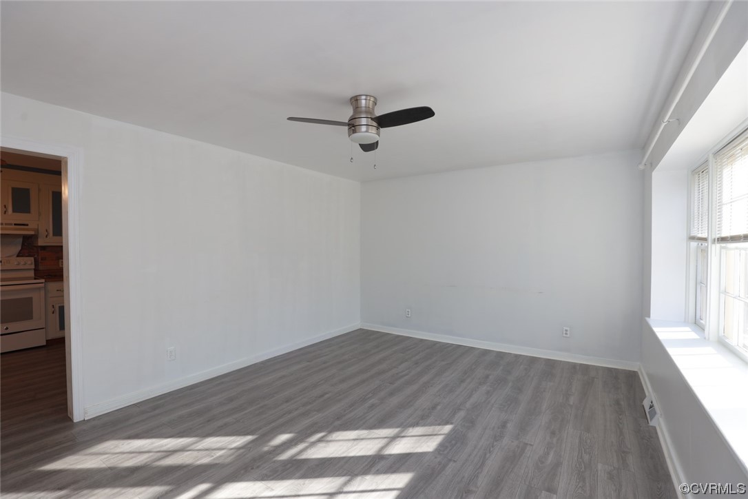 6424 Commander Road Richmond, VA 23224 - Photo 6 of 46 an empty room with wooden floor ceiling fan and windows