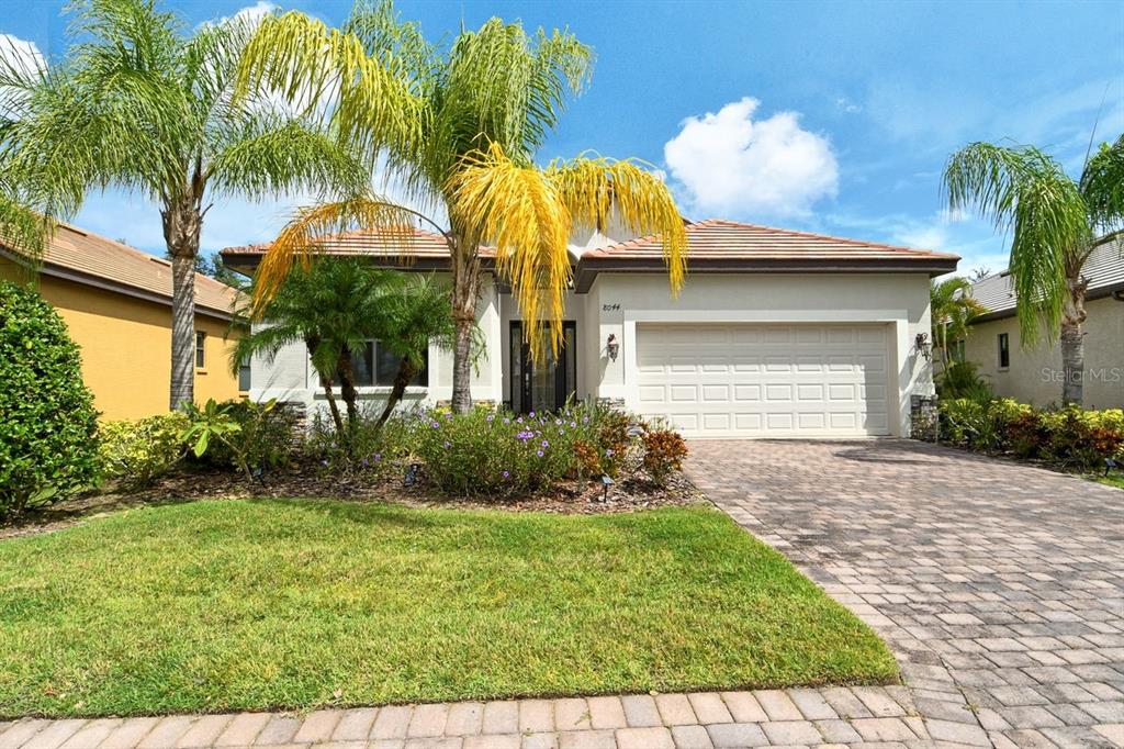 a view of a house with a yard and potted plants