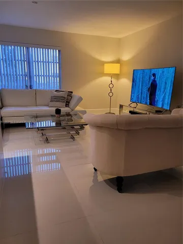 a living room with a couch and a dresser with wooden floor