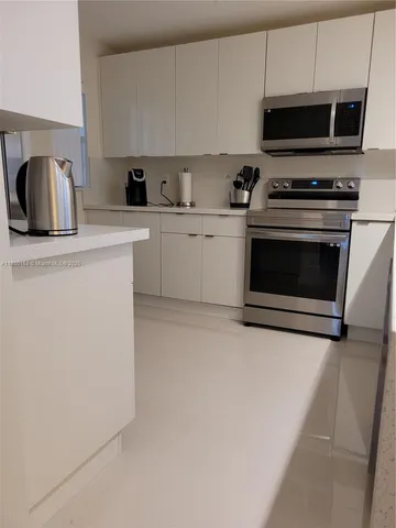 a kitchen with cabinets a microwave a sink and a stove