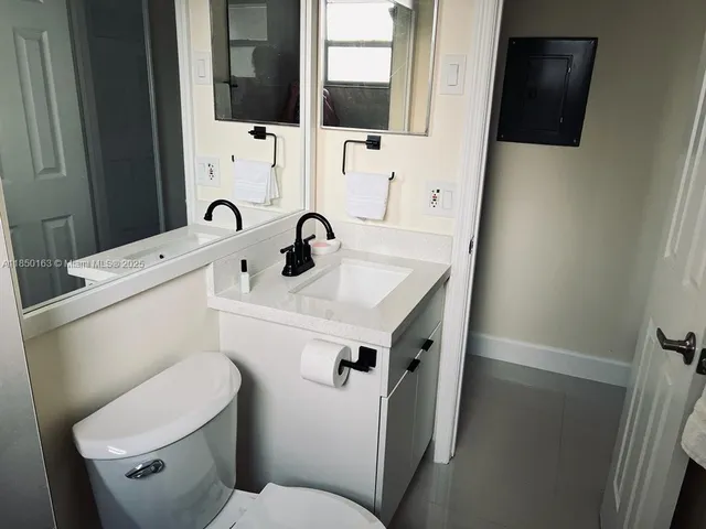 a bathroom with a sink toilet and mirror