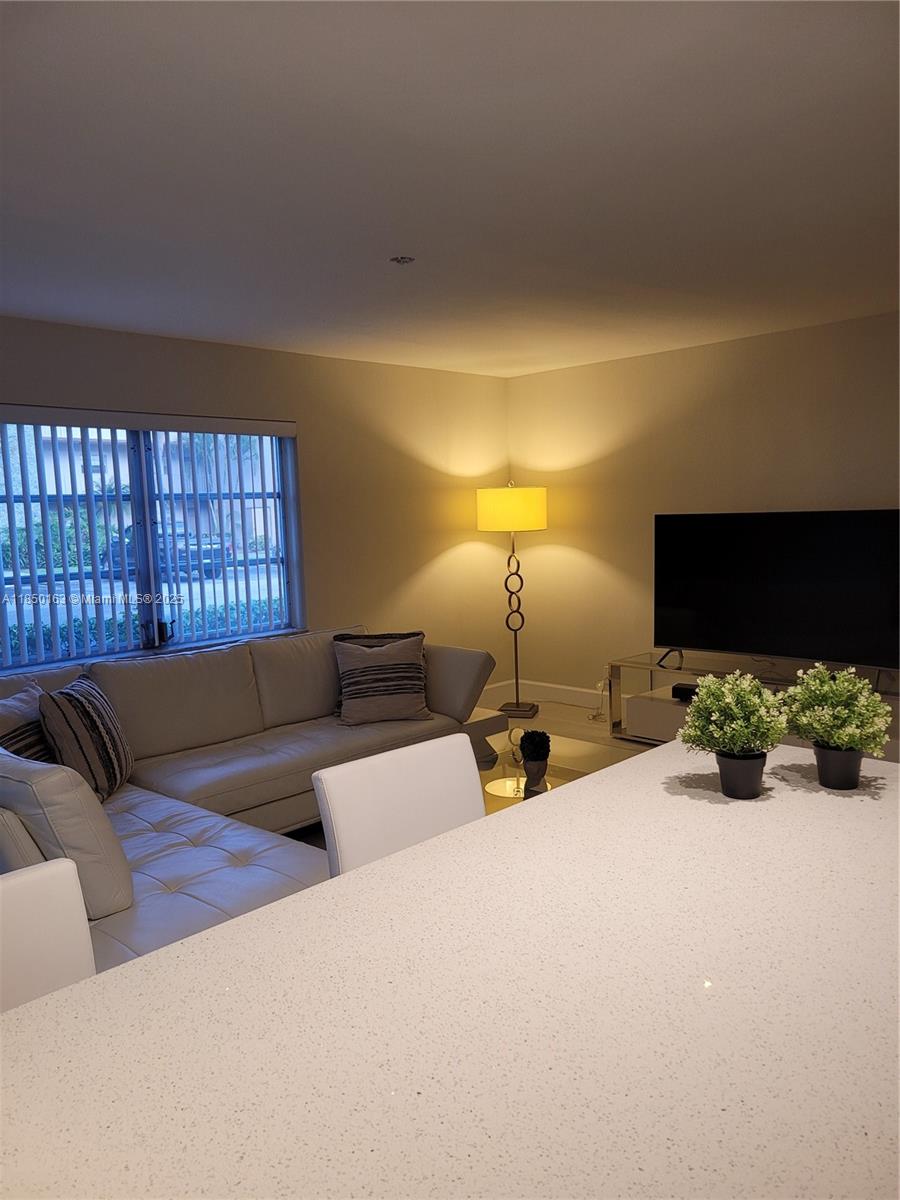 8101 Southwest 24th Court, Unit 108 Davie, FL 33324 - Photo 10 of 10 a bed room with furniture and a flat screen tv