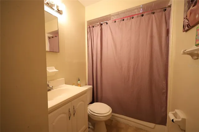 a bathroom with a sink a toilet and shower curtain