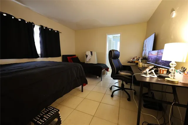 a bedroom with a bed and a lamp on table chair