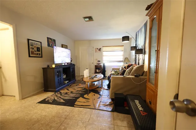 a living room with furniture a flat screen tv and a window