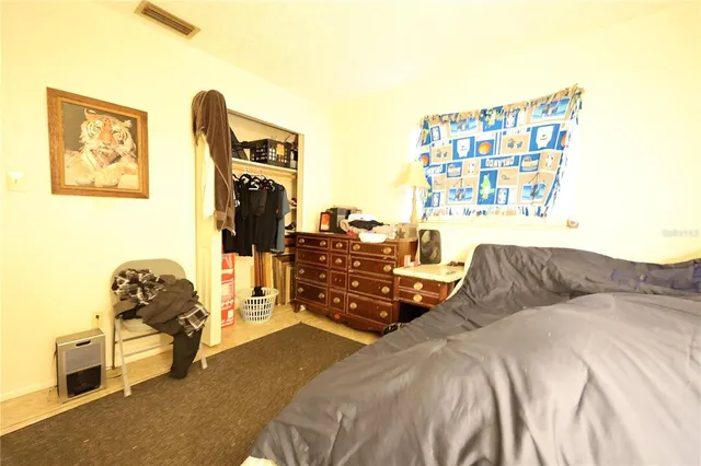 a bedroom with a bed and wooden floor