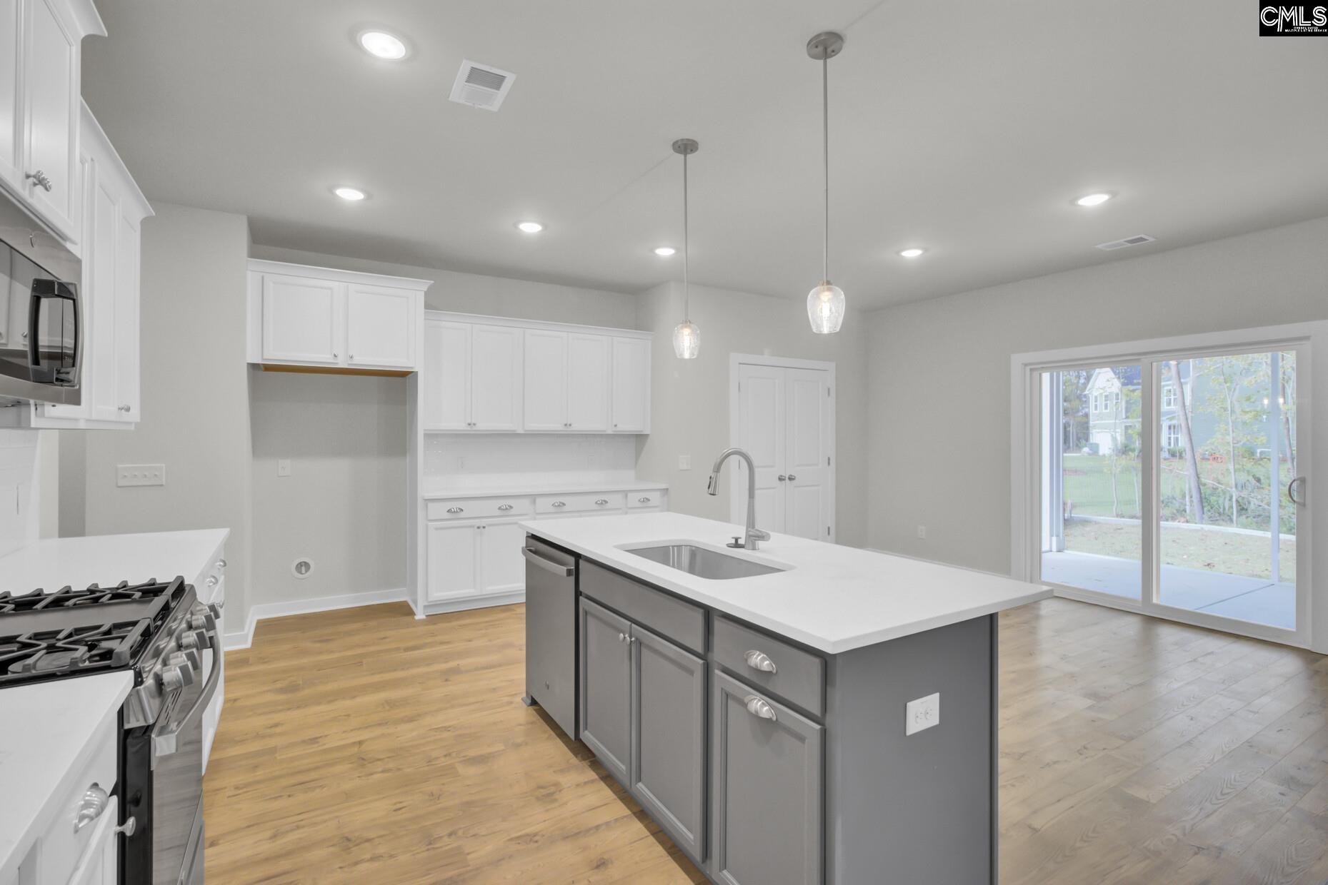 320 Brass Billion Path Lexington, SC 29073 - Photo 14 of 39 a kitchen with a sink stove and wooden cabinets
