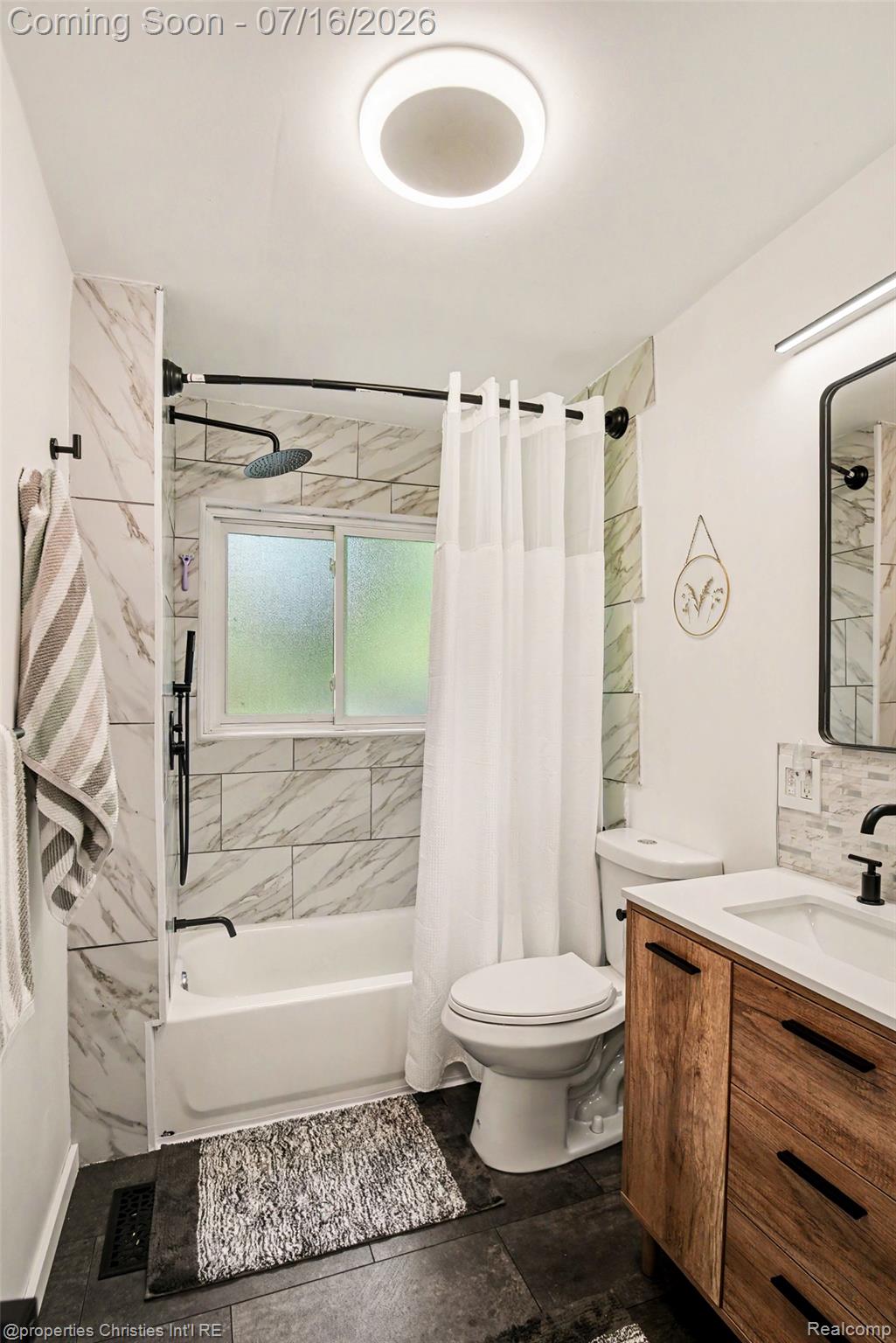 3304 Riverside Drive Port Huron, MI 48060 - Photo 21 of 26 Bathroom featuring a wood-finish vanity with black hardware, white rectangular sink, and matte black faucet