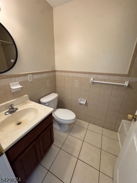 83 Broadway Elizabeth Port, NJ 07206 - Photo 2 of 10 a bathroom with a toilet a sink and mirror