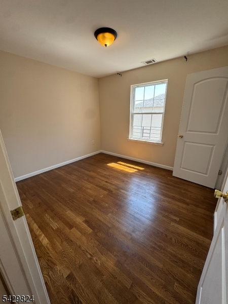 83 Broadway Elizabeth Port, NJ 07206 - Photo 3 of 10 an empty room with wooden floor and windows