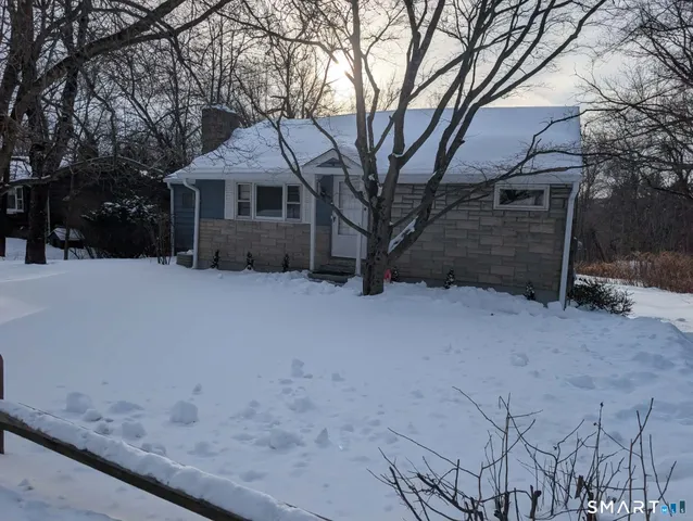 a front view of a house with a yard covered in snow