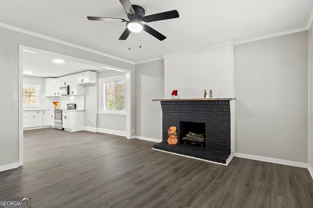 an empty room with wooden floor fireplace and a window