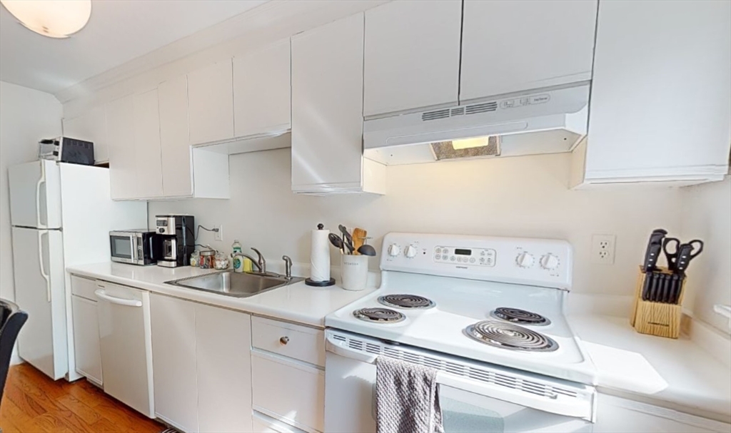 91 Chestnut Street, Unit 6 Brookline, MA 02445 - Photo 3 of 6 a kitchen with a white stove top oven and refrigerator