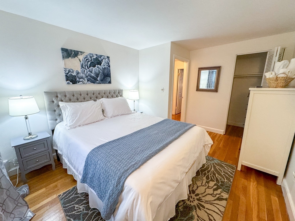 91 Chestnut Street, Unit 6 Brookline, MA 02445 - Photo 4 of 6 a bedroom with a bed and a lamp on dresser