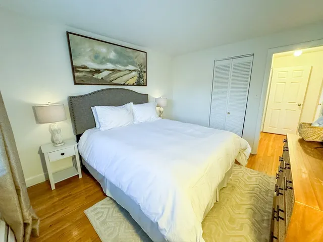 a bedroom with a bed and a painting on the wall