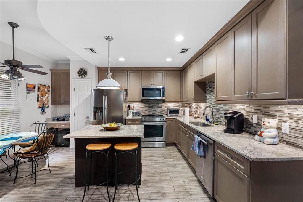 763 Date Palm Lane St. Petersburg, FL 33707 - Photo 3 of 34 a kitchen with granite countertop a sink a counter top space appliances and cabinets