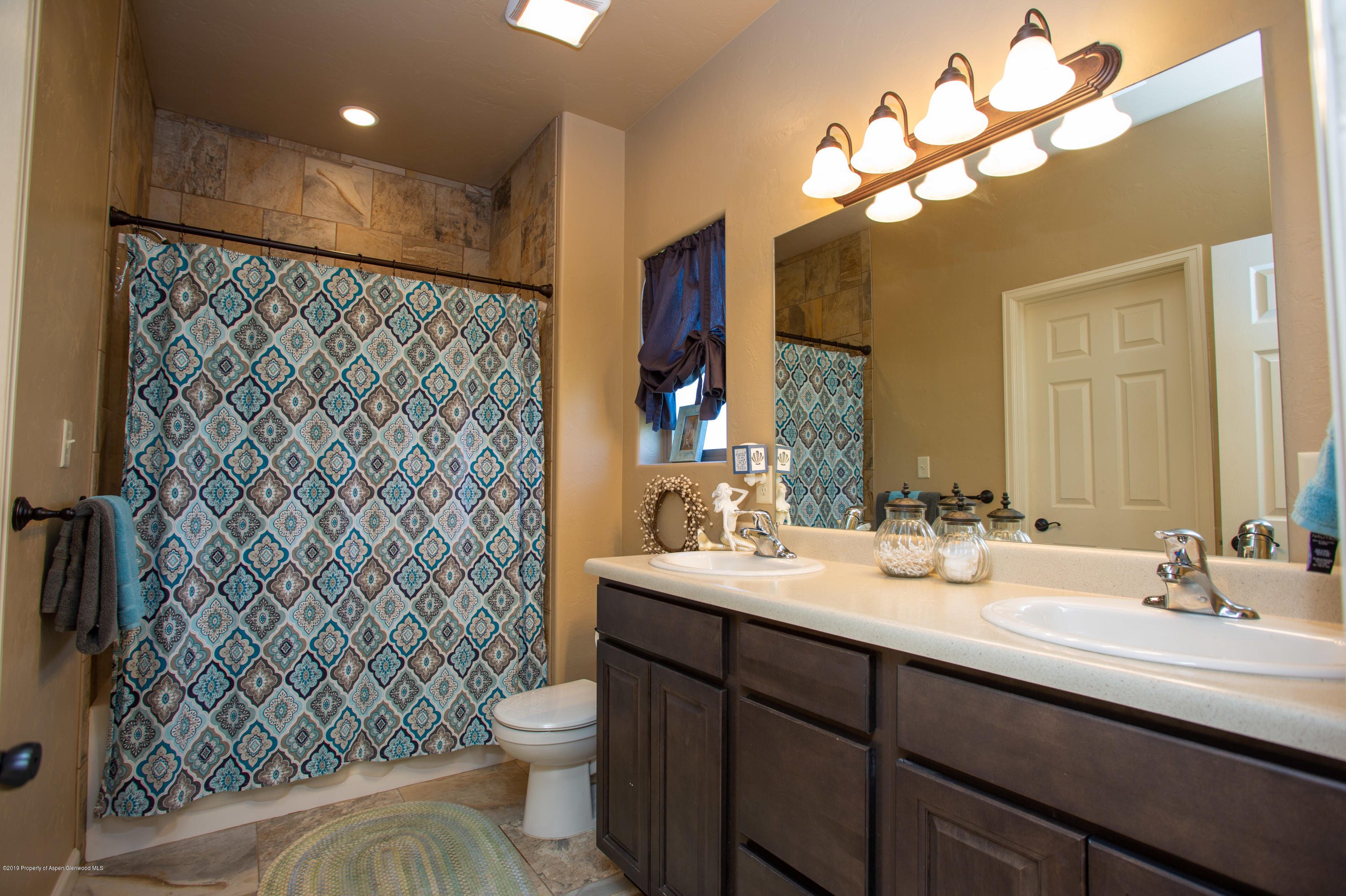 1930 Promontory Circle Rifle, CO 81650 - Photo 11 of 19 a bathroom with a double vanity sink mirror and toilet