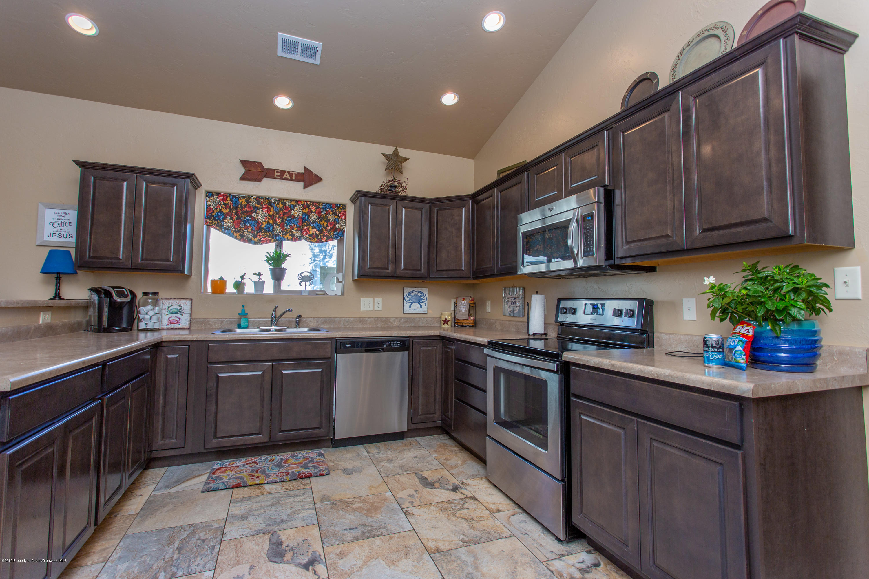 1930 Promontory Circle Rifle, CO 81650 - Photo 3 of 19 a kitchen with stainless steel appliances granite countertop a sink stove and cabinets