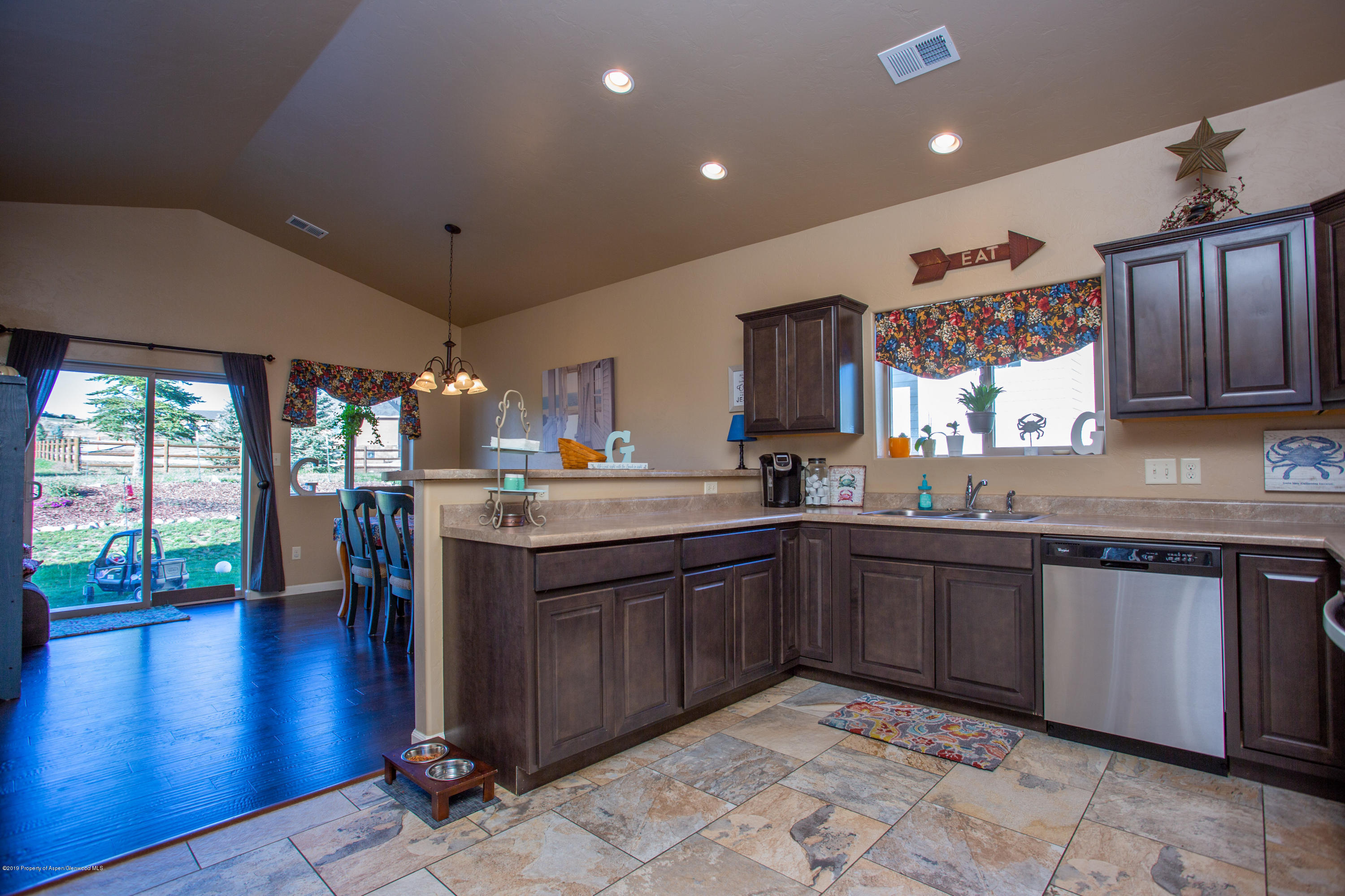 1930 Promontory Circle Rifle, CO 81650 - Photo 4 of 19 a kitchen with stainless steel appliances granite countertop a sink dishwasher stove and wooden cabinets