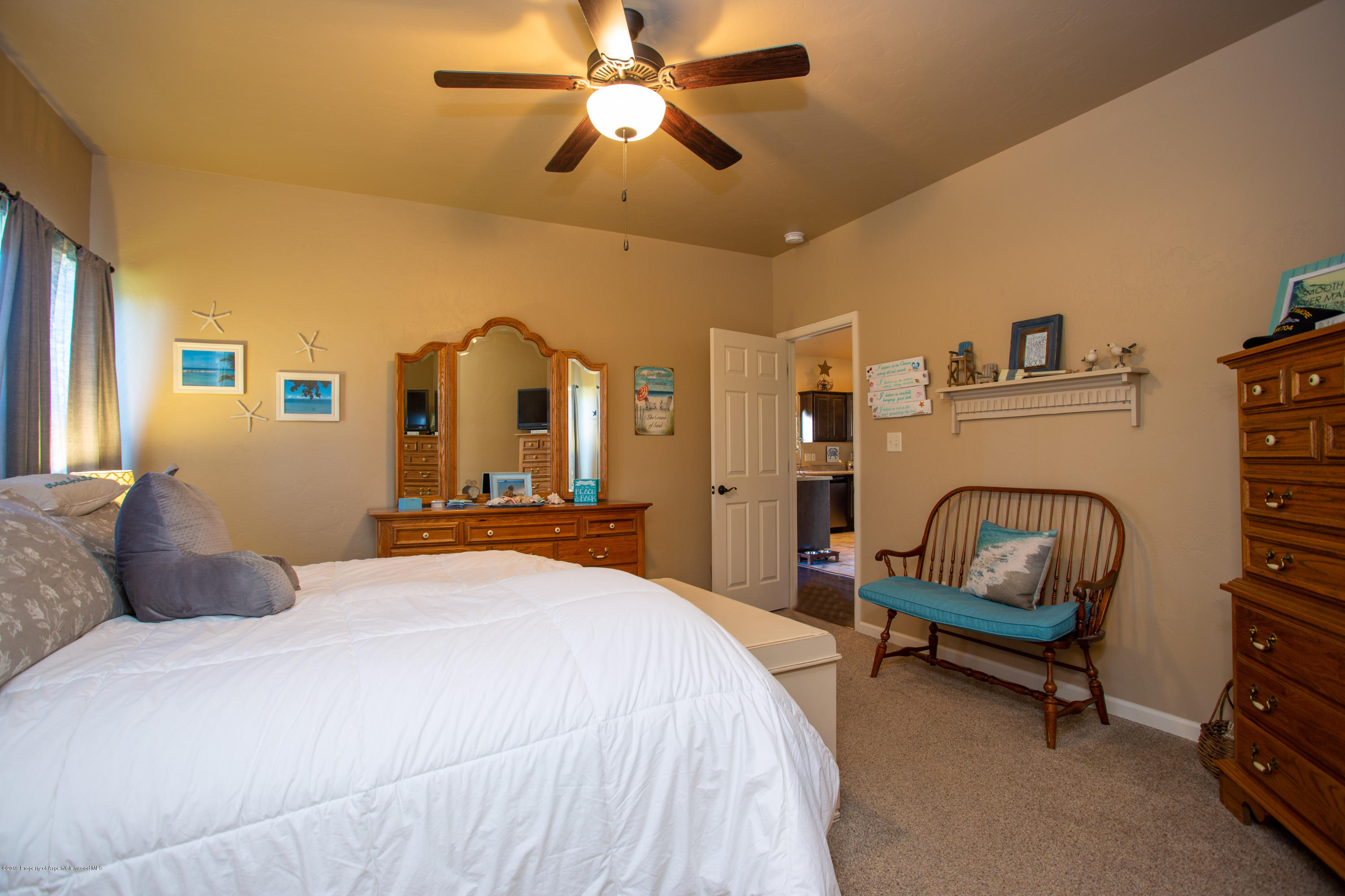 1930 Promontory Circle Rifle, CO 81650 - Photo 10 of 19 a bedroom with a bed a couch and a chandelier