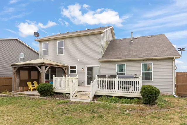 a view of a house with a yard and deck
