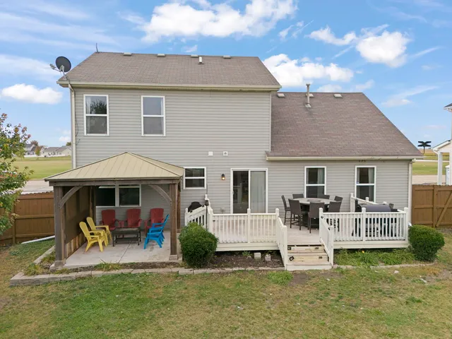 a patio with a table and chairs under an umbrella