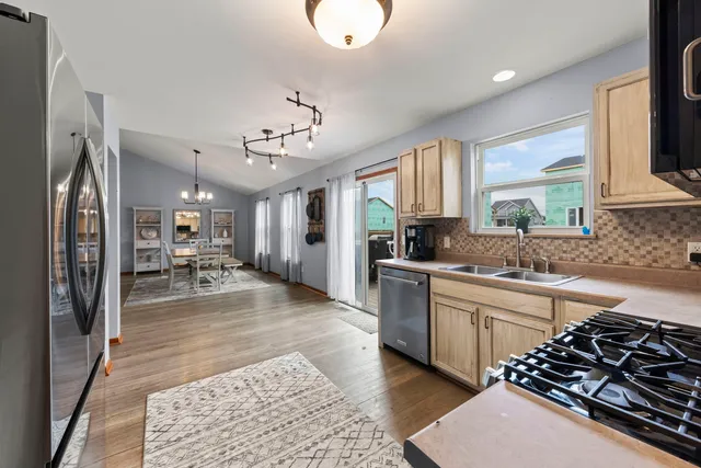 a large kitchen with stainless steel appliances granite countertop a lot of counter space and a sink