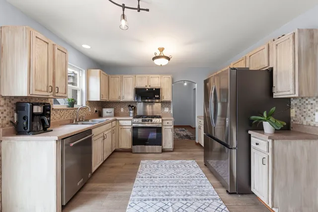 a kitchen with stainless steel appliances granite countertop a refrigerator stove and sink