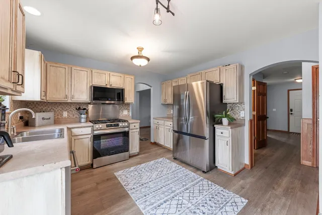 a kitchen with stainless steel appliances granite countertop a refrigerator stove and sink
