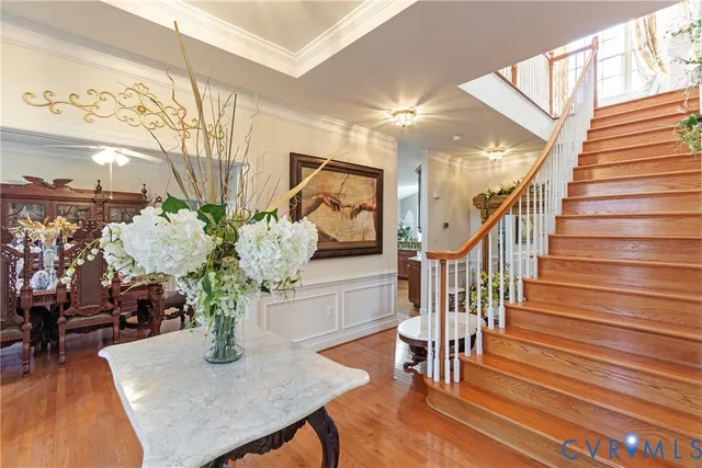 a dining room with wooden floor furniture and a potted plant
