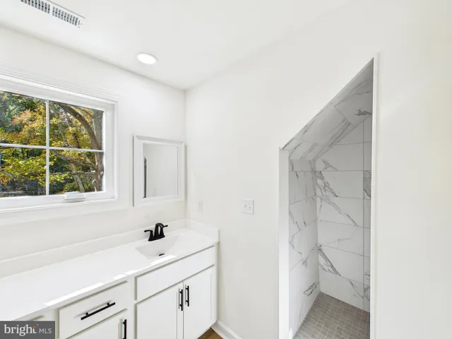 a bathroom with a sink a toilet and a window