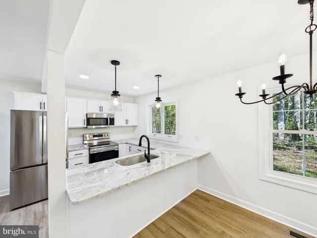 a kitchen with stainless steel appliances a sink a stove a refrigerator and cabinets