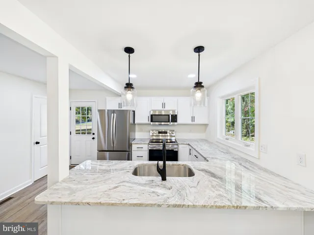 a kitchen with kitchen island white cabinets and refrigerator