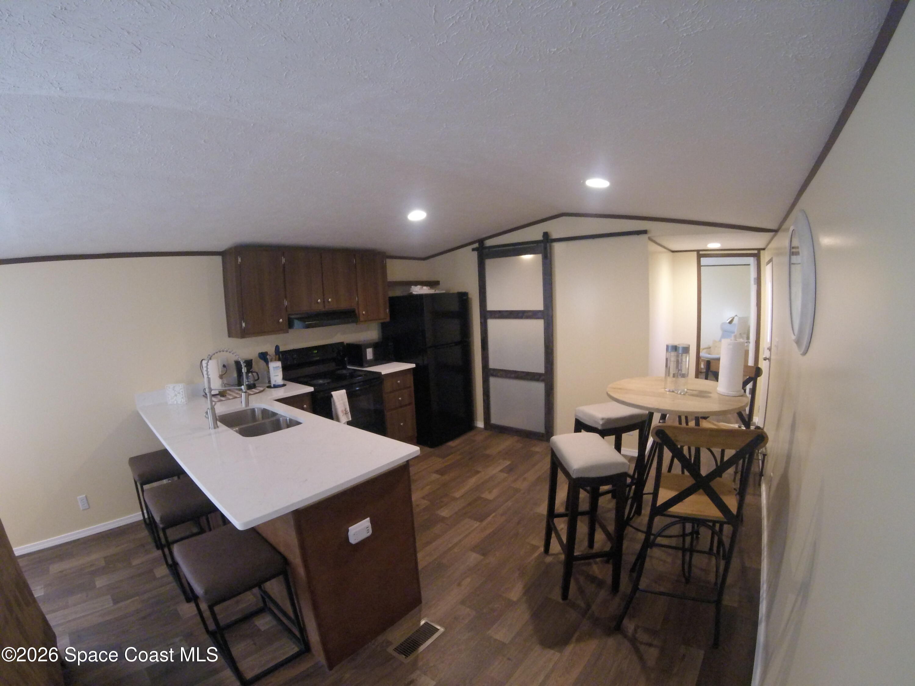2501 Amberly Road Northeast Palm Bay, FL 32905 - Photo 12 of 25 a kitchen with a dining table chairs and refrigerator