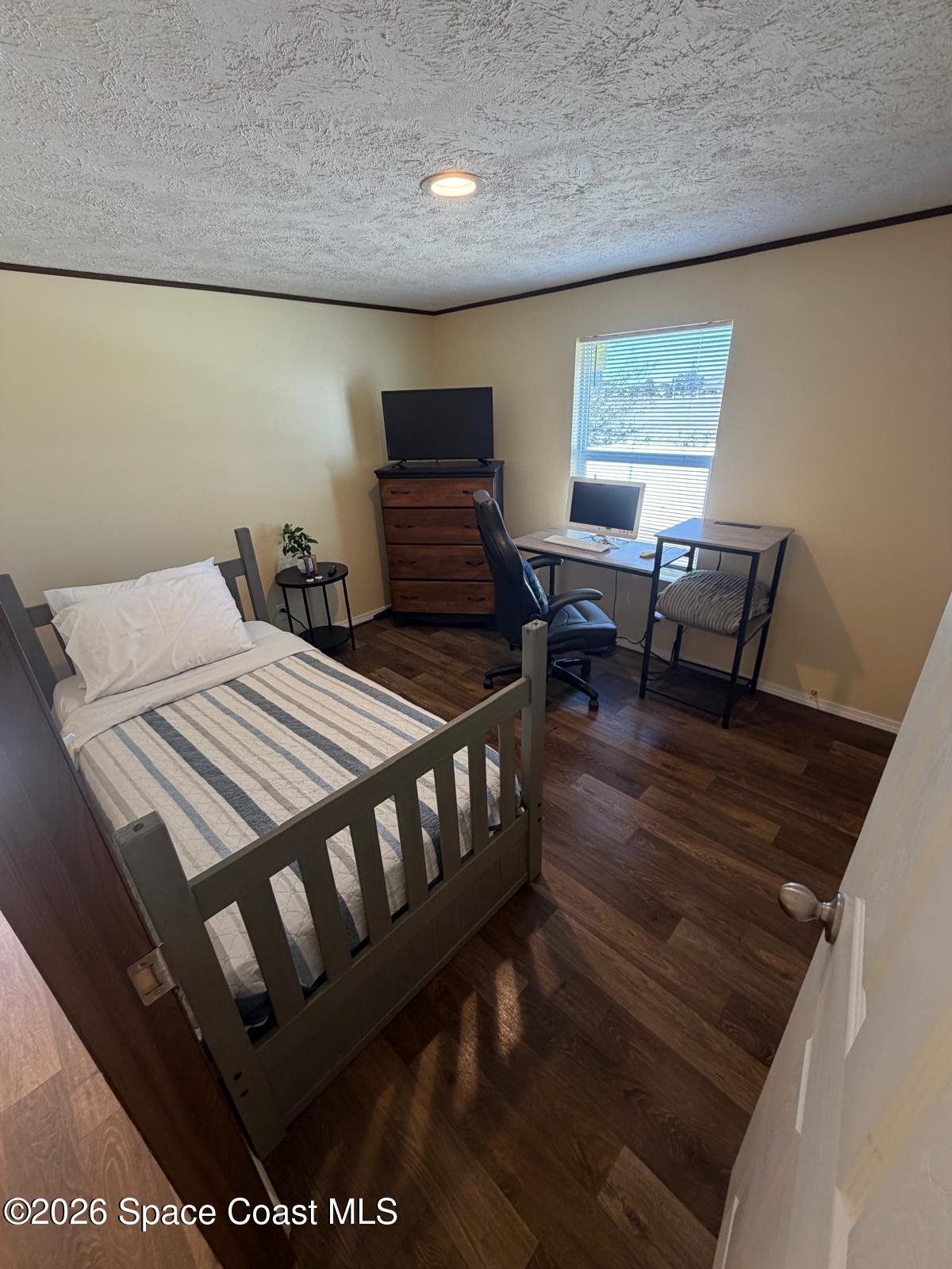 2501 Amberly Road Northeast Palm Bay, FL 32905 - Photo 22 of 25 a bedroom with a bed a table and chair