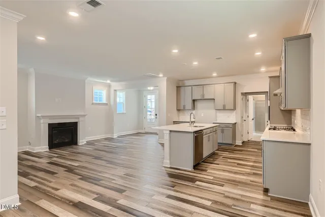 a large kitchen with granite countertop a large counter top appliances and cabinets