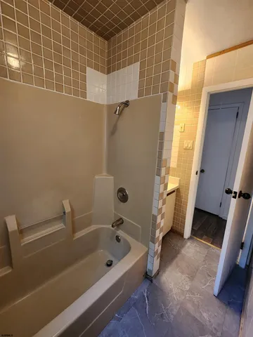 a bathroom with a tub a sink and a shower