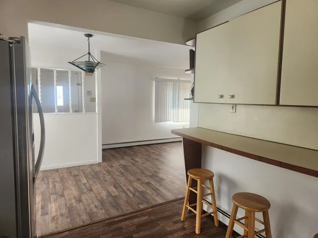 a view of a room with wooden floor and cabinets