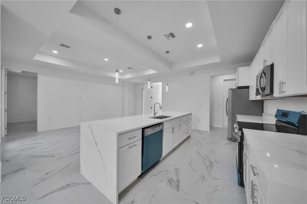 4308 15th Street Southwest Lehigh Acres, FL 33976 - Photo 5 of 27 a kitchen with stainless steel appliances a sink a stove a refrigerator and cabinets