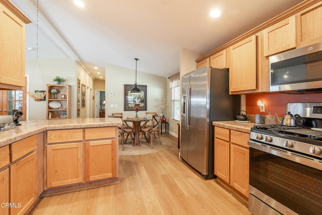 1273 South Rice Road, Unit 12 Ojai, CA 93023 - Photo 8 of 27 a kitchen with stainless steel appliances a stove a sink dishwasher a refrigerator oven and white cabinets with wooden floor
