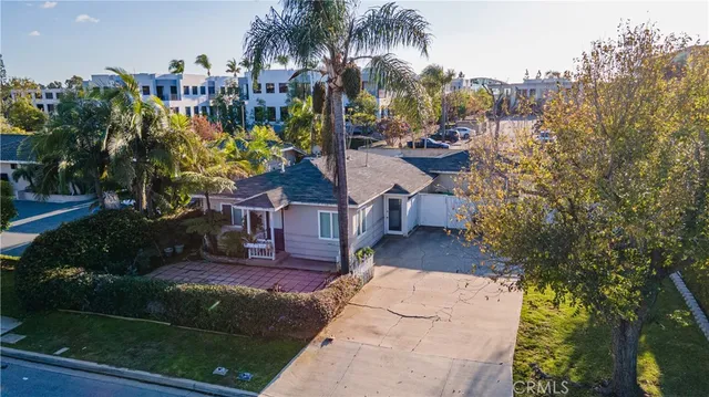 a view of a house with a yard and potted plants