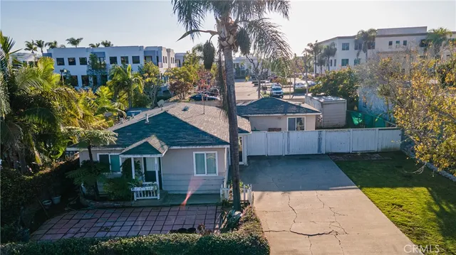 a view of a house with a yard and potted plants