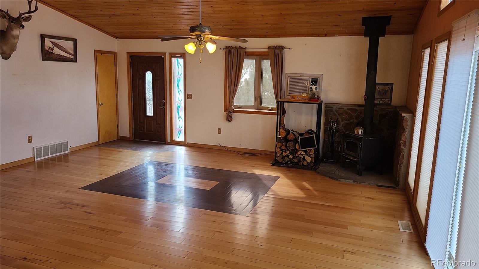 445 Rosalie Road Bailey, CO 80421 - Photo 7 of 21 an empty room with wooden floor and windows